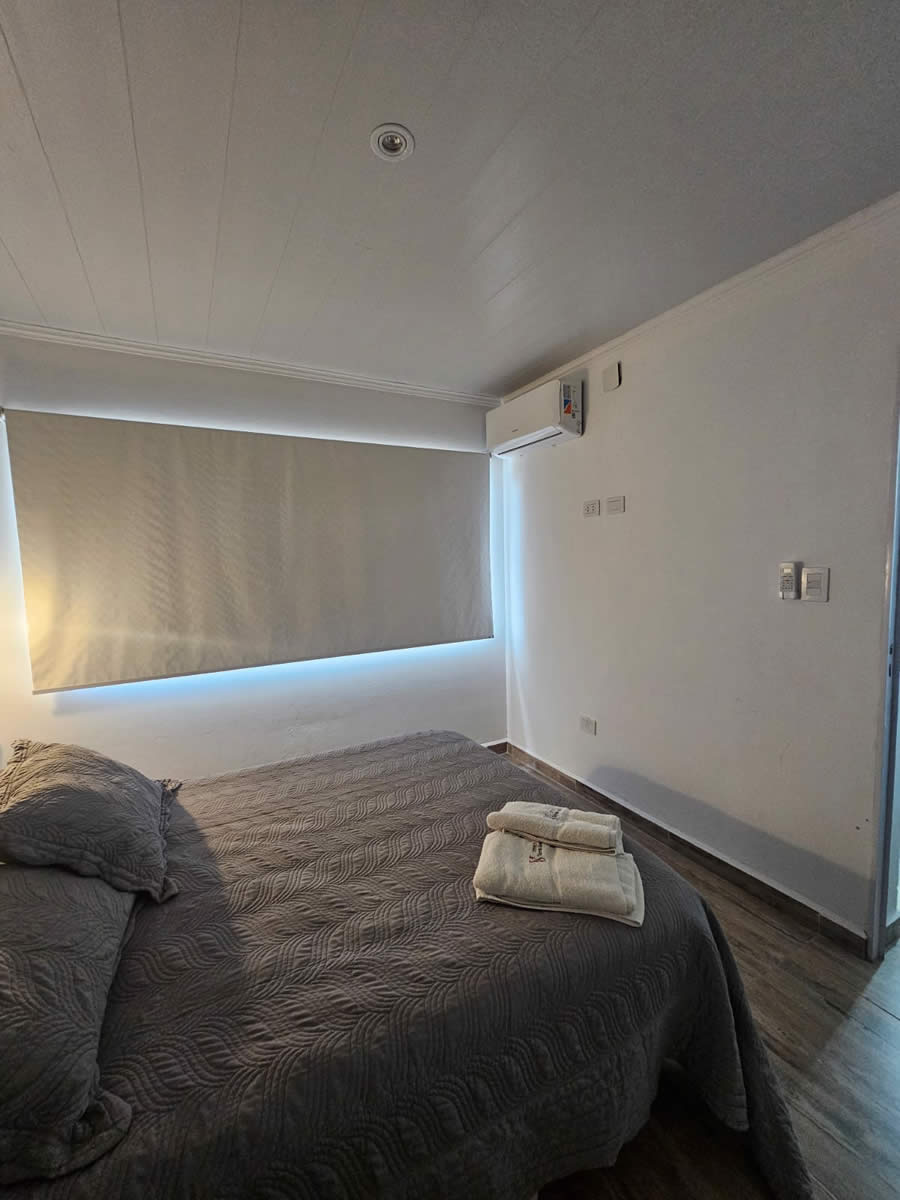 Cama matrimonial en el dormitorio principal del Departamento 4